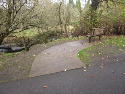 Hard surface trail – bench over looking Salmon Creek – gravel on the side of path